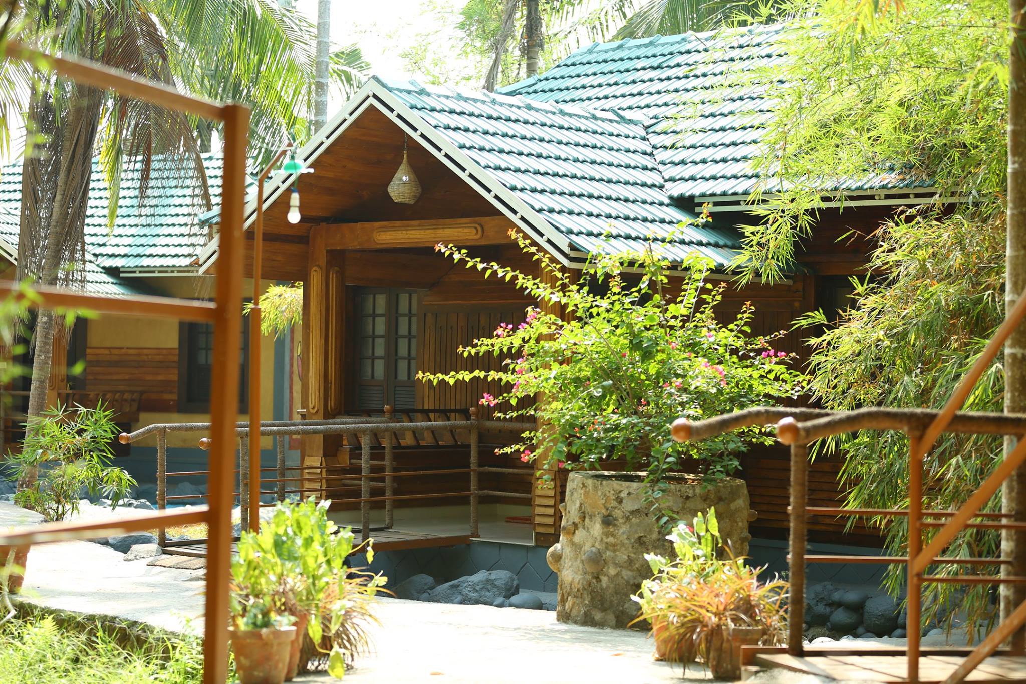 Private cottage surrounded by tropical trees at Yamunatheeram Resort Kerala