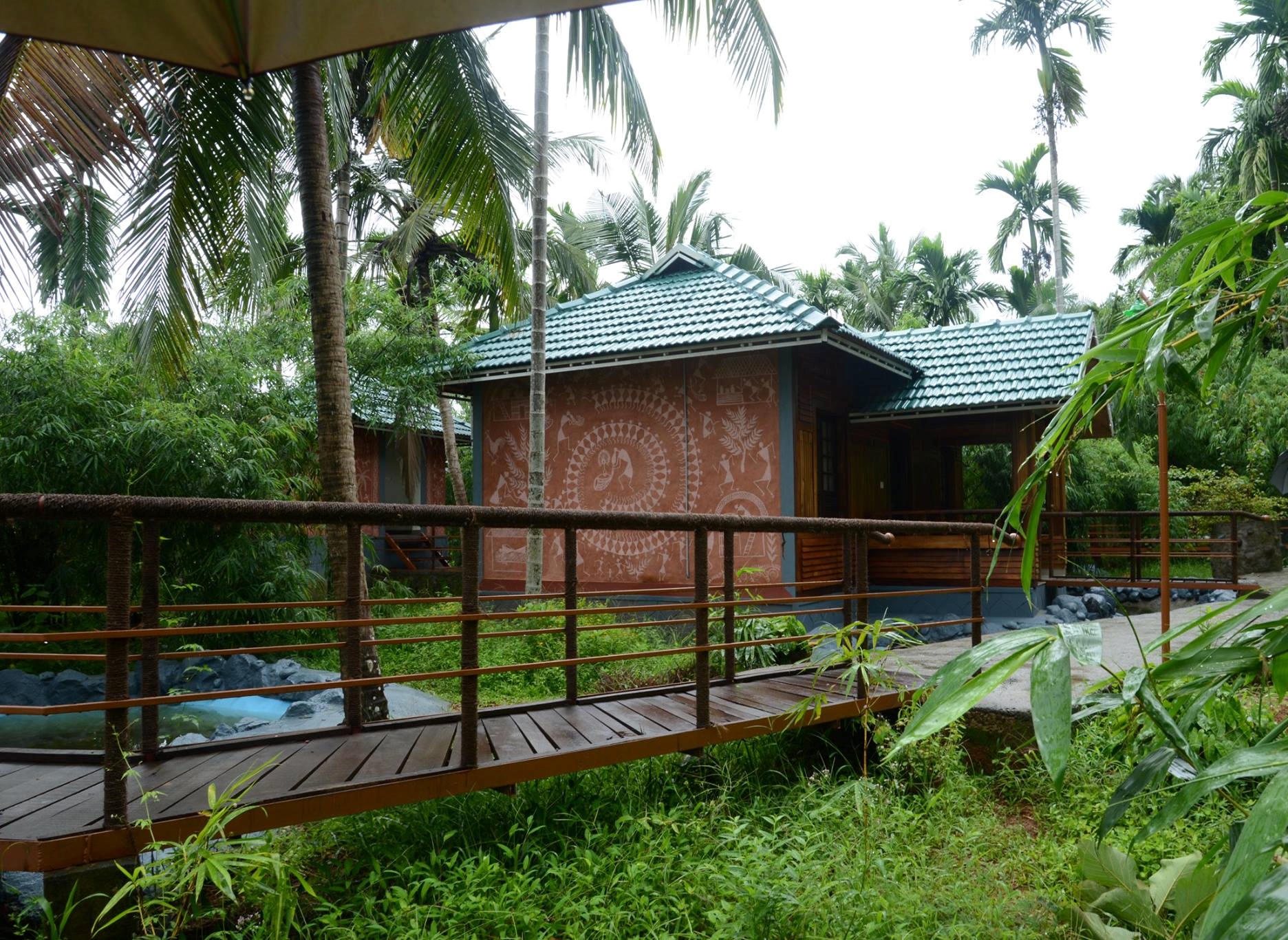 Outdoor cottage with bridge surrounded by nature at Yamunatheeram