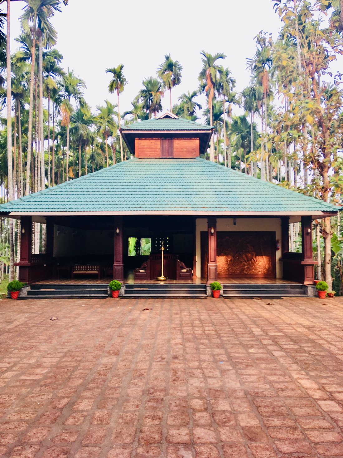 Reception pavilion at Yamunatheeram Resort surrounded by palms and traditional Kerala architecture